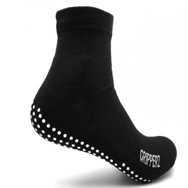 A black GripSox non-slip sock with a textured rubber sole and a stretchy top for wider calf or ankle fit.