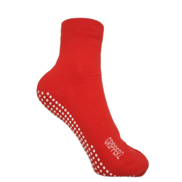 A red GripSox non-slip sock with a textured rubber sole and a stretchy top for wider calf or ankle fit.
